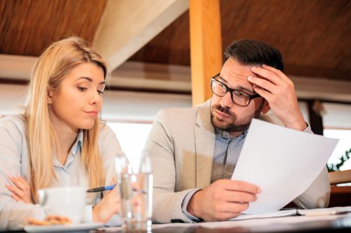 Couple facing a divorce going over documents. Visual concept for a legal blog discussing divorce and the small business owner.