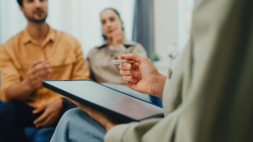 Closeup of young couple in serious discussion with a mediator. Visual concept for a family law blog discussing divorce mediation.