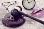 Gavel, rings and money on wooden table - BartonWood