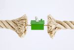A fraying tug-of-war rope pulling on a house with US Dollar bills. - BartonWood