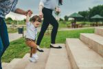 Baby walking with help of parents