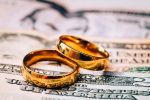 Wedding rings placed on top of dollar bills. How to keep divorce costs down.