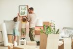 Portrait of happy father with two sons hanging pictures on wall while moving in to dad's new home, concept for Tips for Making Smoother Parenting Time Transitions