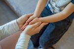 Parent and child's hands touching. Sharing physical and emotional pain with children. Visual concept for family law blog about child custody mistakes.