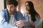 Close-up of unhappy young couple sitting apart thinking about divorce. Visual concept for family law blog discussing tips on how to tell your spouse “I Want a Divorce”