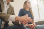 An anxious couple. Close up of the man's hands. Visual concept for a family law blog discussing the key differences between collaborative and traditional divorce.