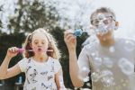 Happy brother and sister blowing bubbles, visual concept for a family law blog discussing child support for special needs children.