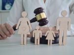 A judge holds a gavel above wooden figures representing a family. Visual concept for family law blog discussing divorce during pregnancy.